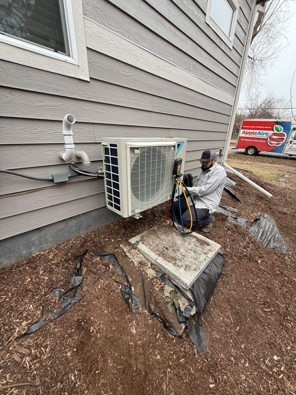 Apple Aire technician installing a Daikin heat pump in Applewood, Colorado
