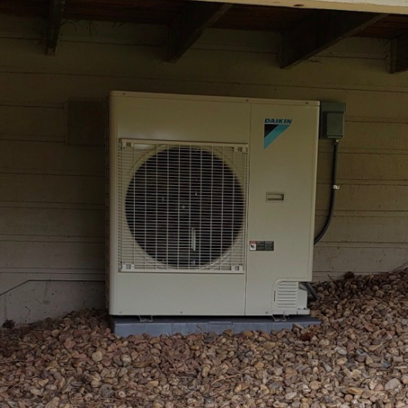 Daikin heat pump installed beneath a covered exterior area