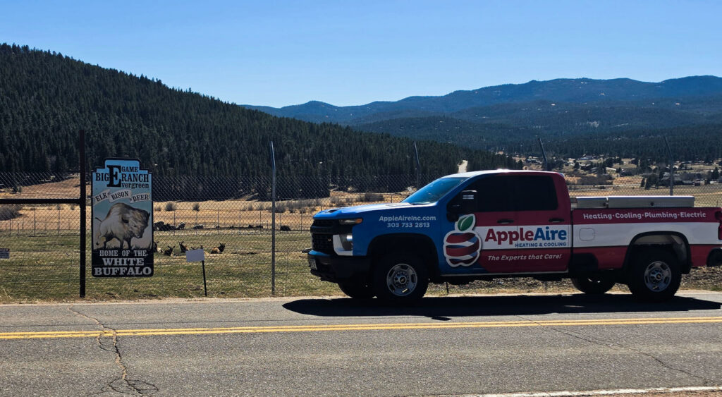 Apple Aire Heating & Cooling car parked in Evergreen, Colorado outside of the Big E Game Ranch on a beautiful blue sky day